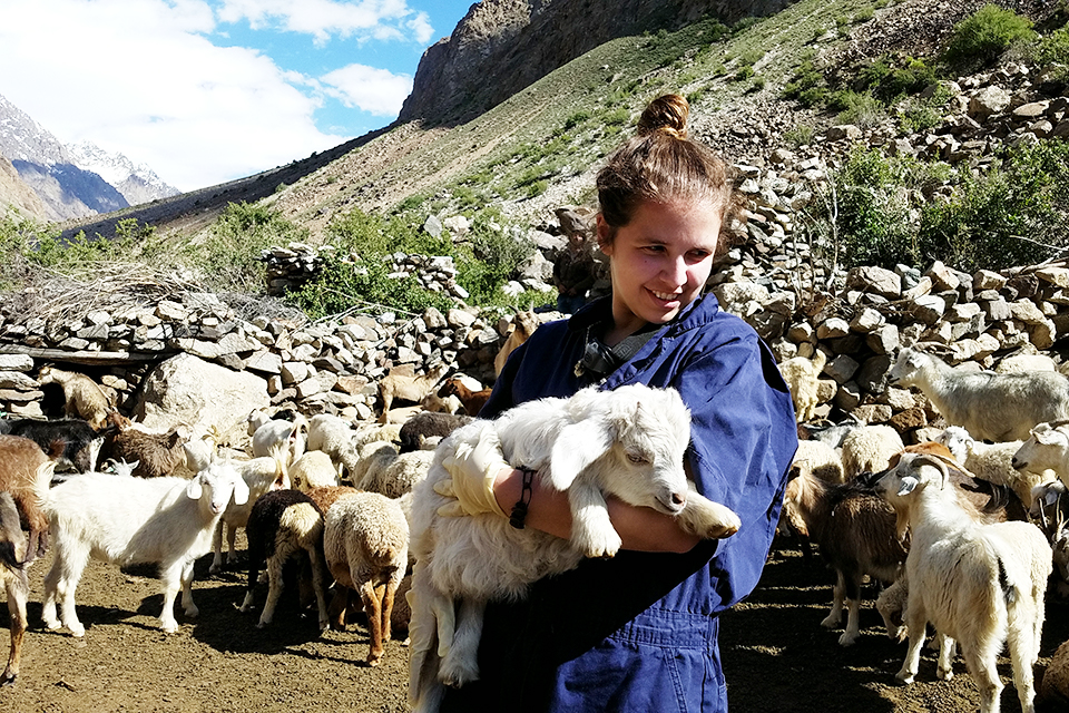 CVM student holding baby sheep in Tajikistan