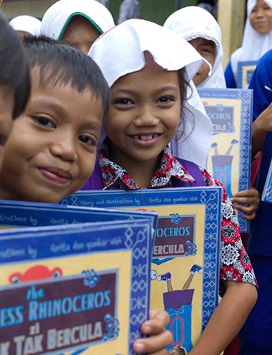 School children holding children's books about a rhinoceros