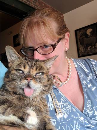A photo of Karyn Bischoff with her cat both looking at the camera