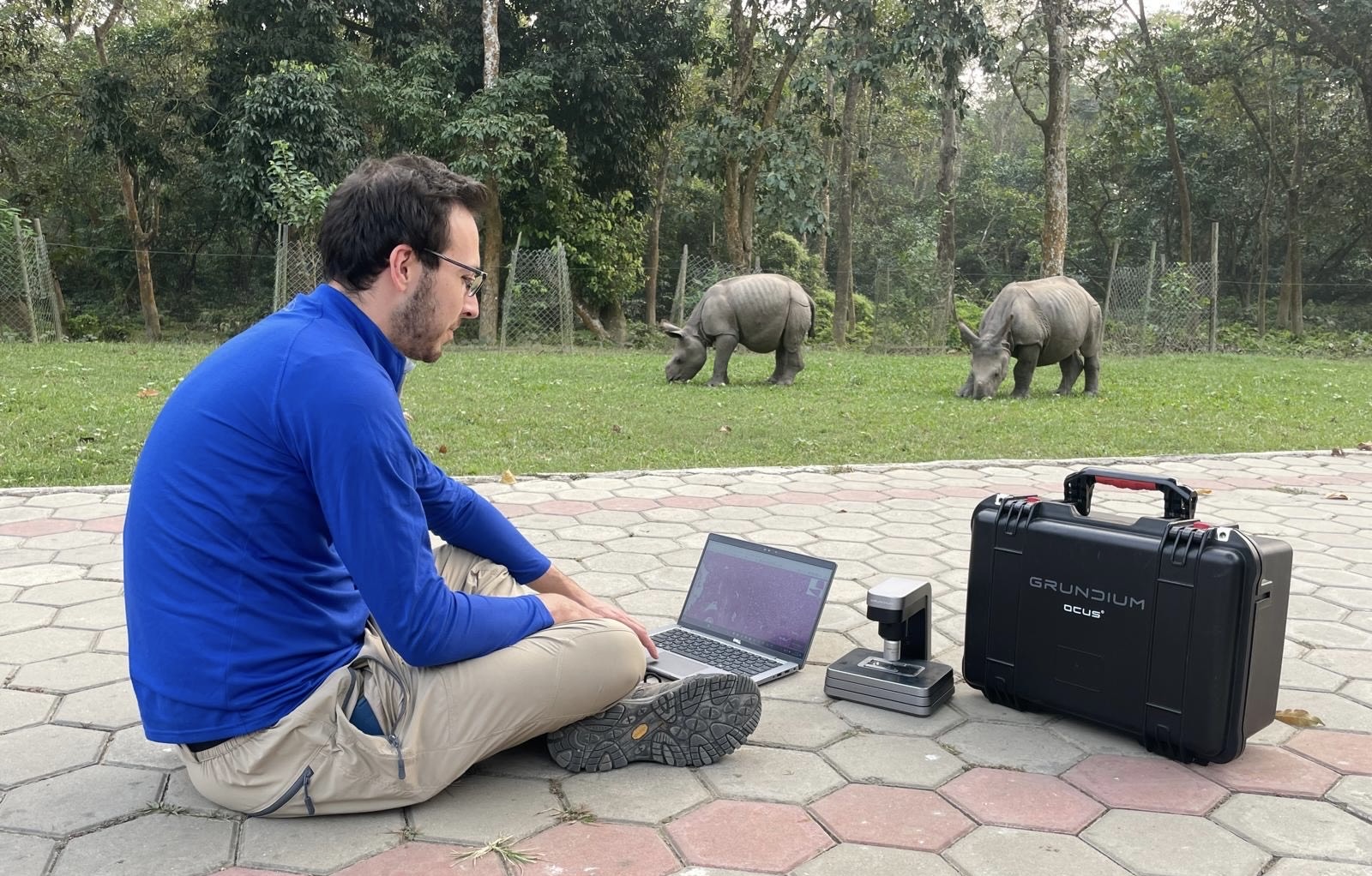 Carmen Smith analyzing samples with rhinos in the background