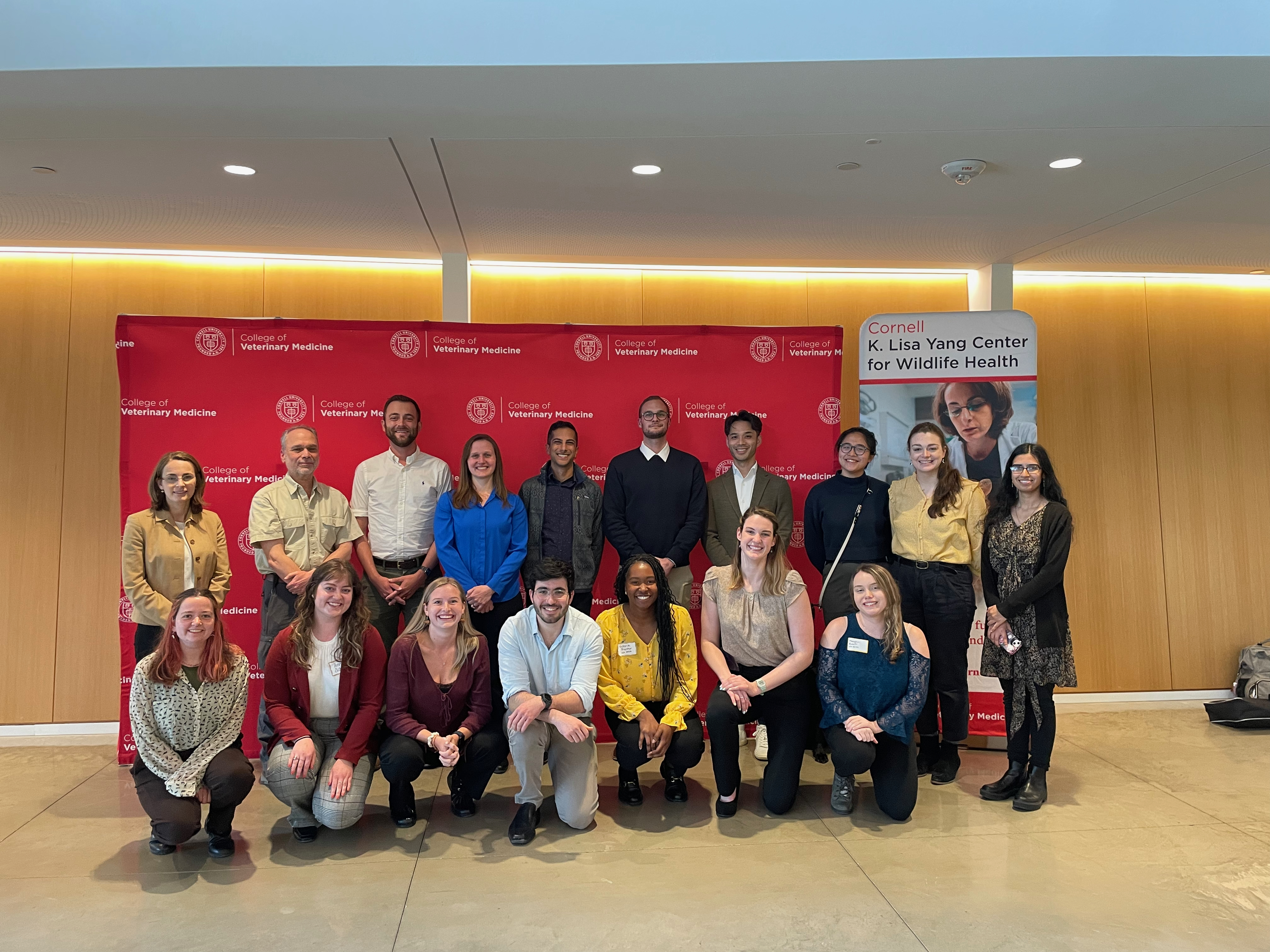 Dr. Reed posing with several other people in front of a red Cornell background.