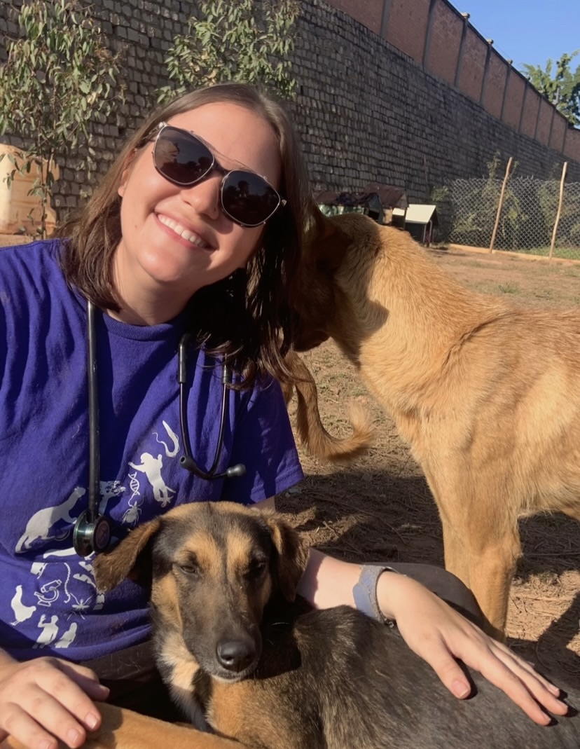 Shayna smiling next to a dog.