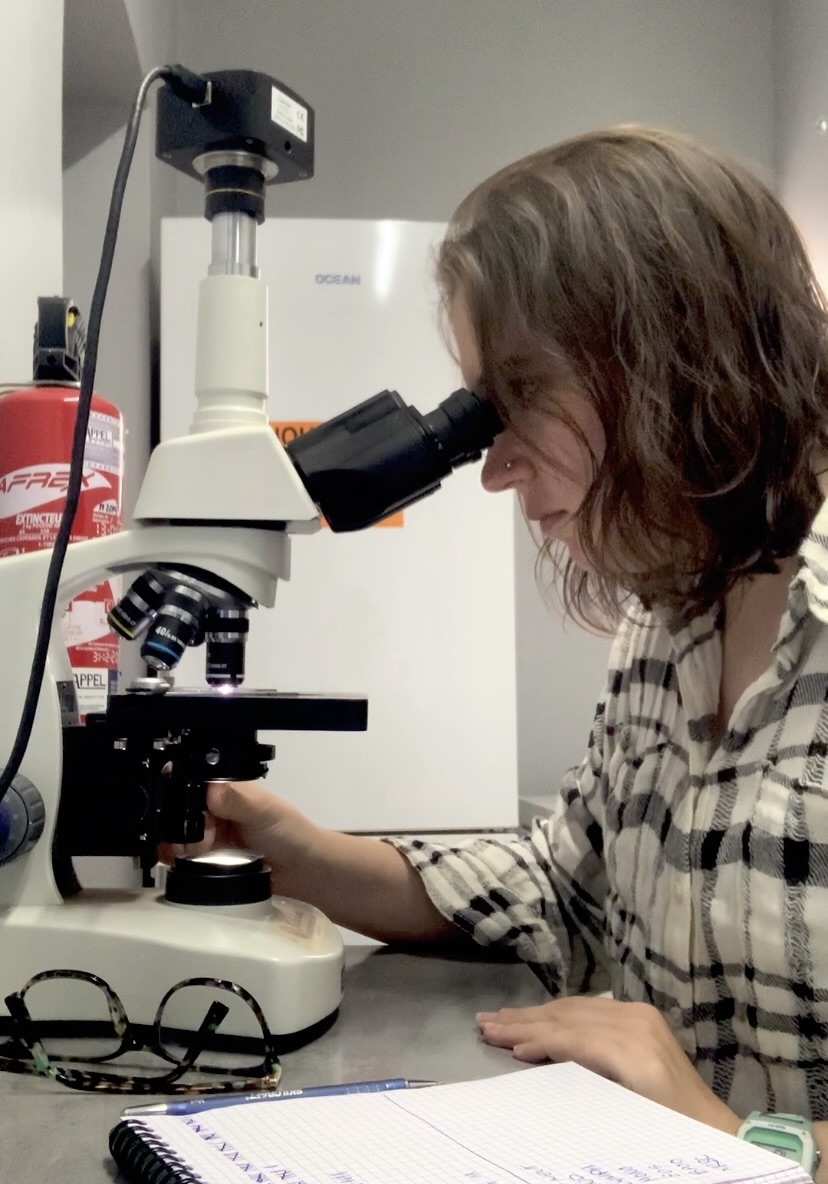 Shayna looking through a microscope.