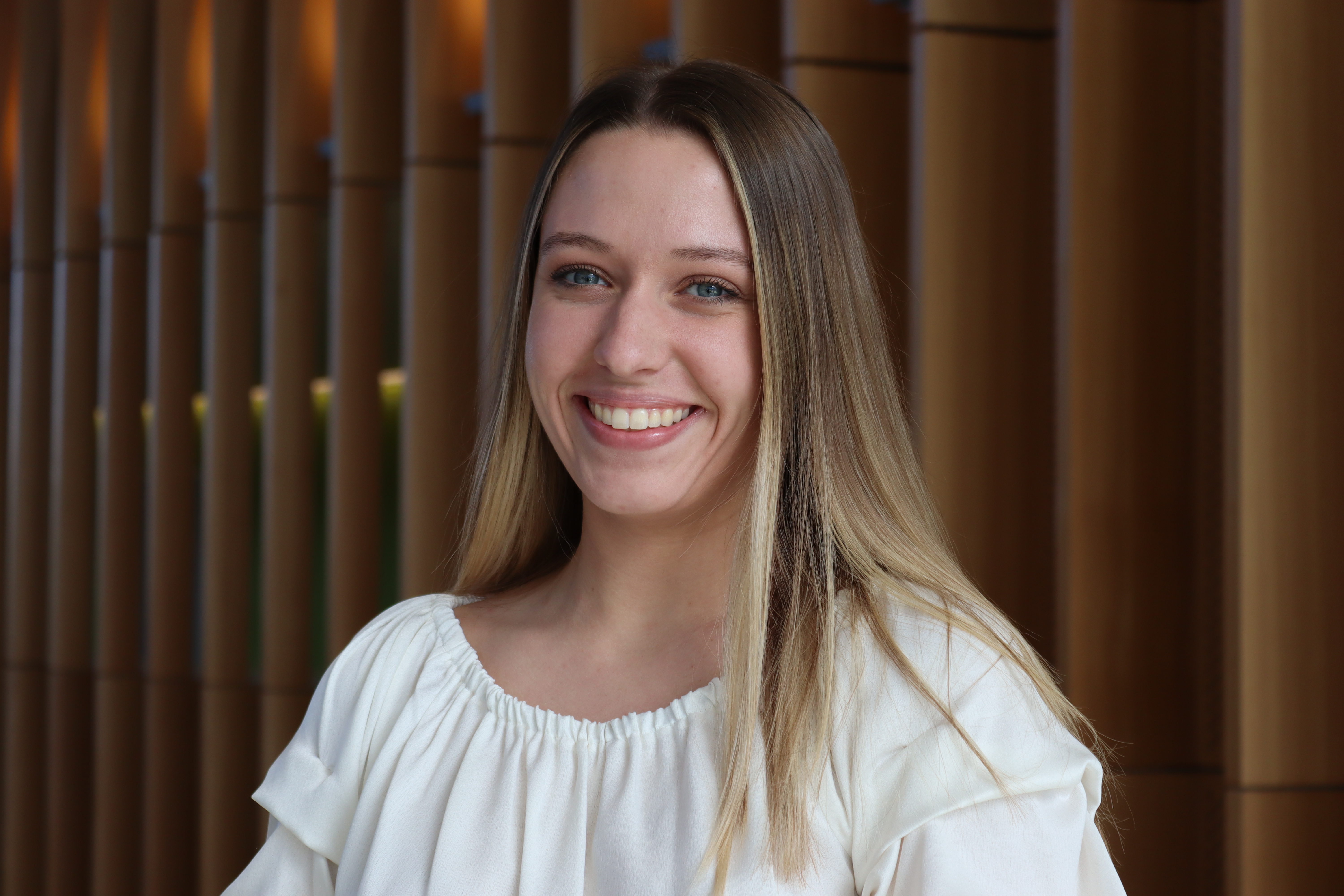 Erica Jackson is wearing a white shirt and smiling at the camera.