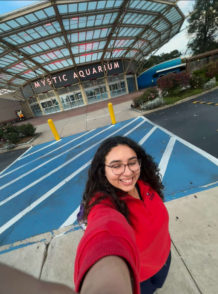 Natalia is standing in front of the Mystic Aquarium.