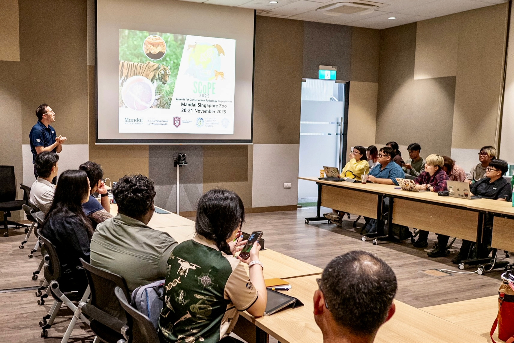 Carmen Smith presenting to several people sitting at tables.