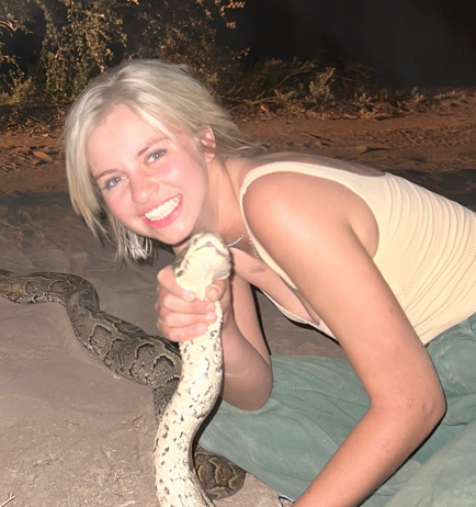 Katie Johnson smiling while holding a snake.