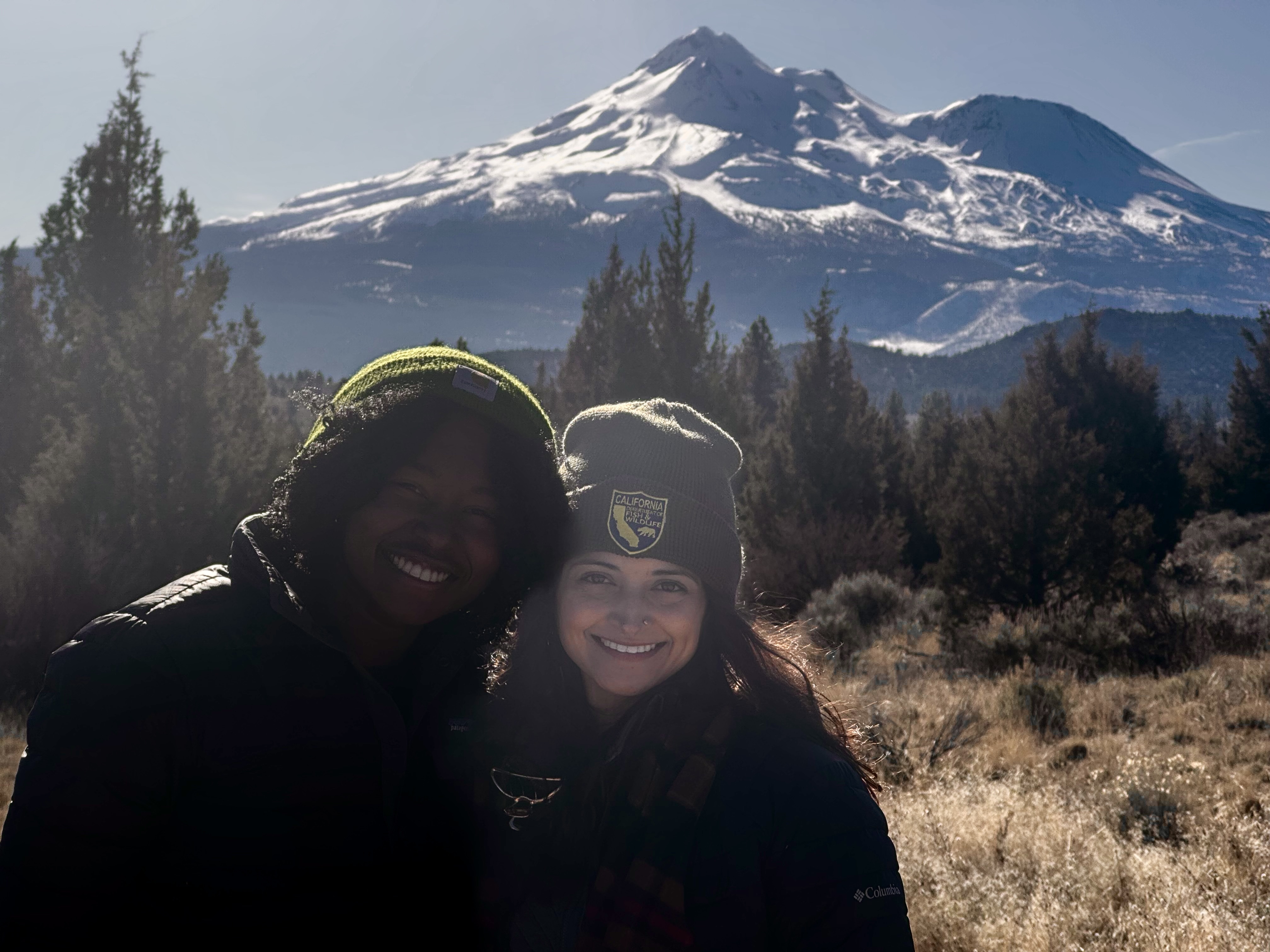 Victoria Priester and Dr. Jane Riner smile at the camera with a mountain in the background.