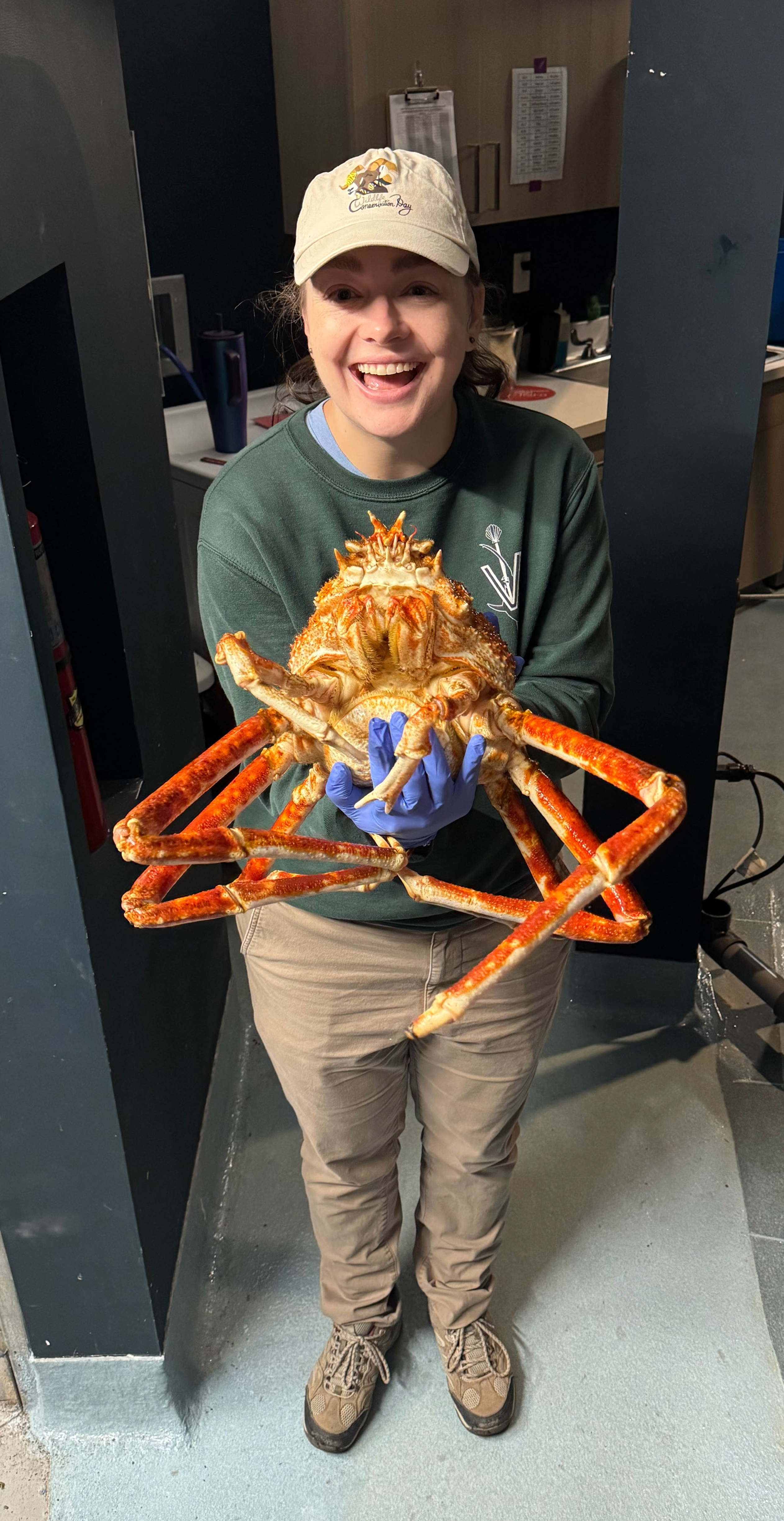 Kathleen holding a spider crab while smiling at the camera.
