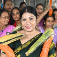 Purnima surrounded by other women all holding paper storks 