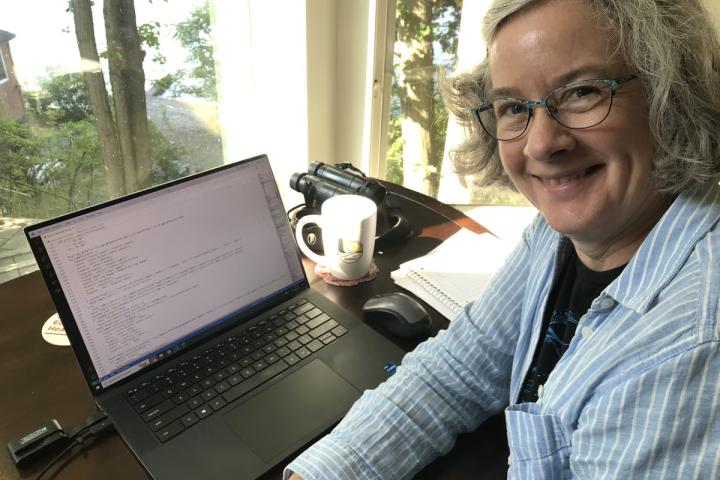 A portrait of Rachel Abbott sitting at her desk.