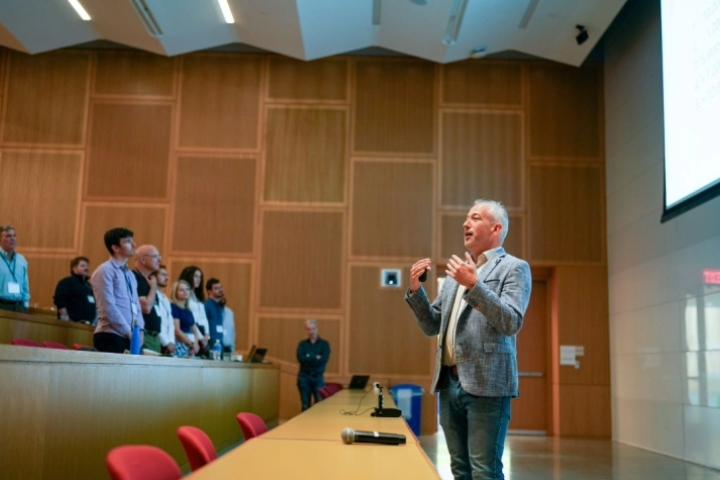 Speaker Dr. Miel Hostens, stands in front of a lecture hall speaking to attendees