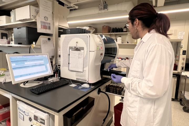 Student wearing a lab coat working in the lab