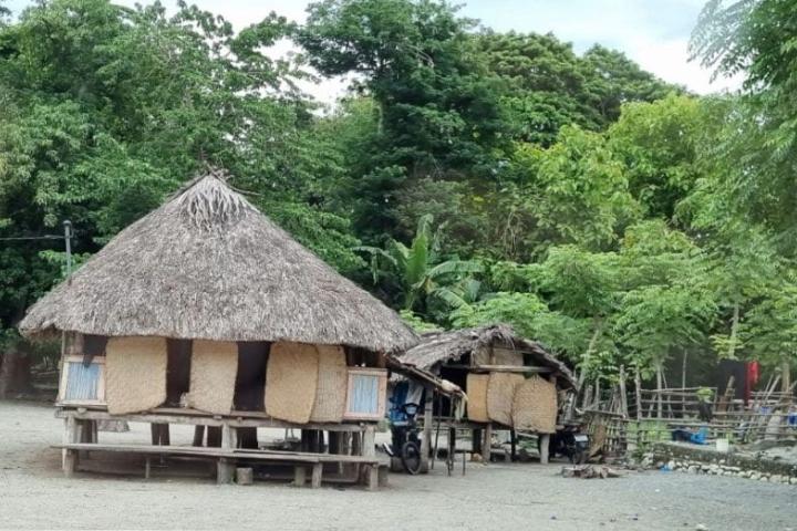 Two huts that are raised from the ground in a remote setting.