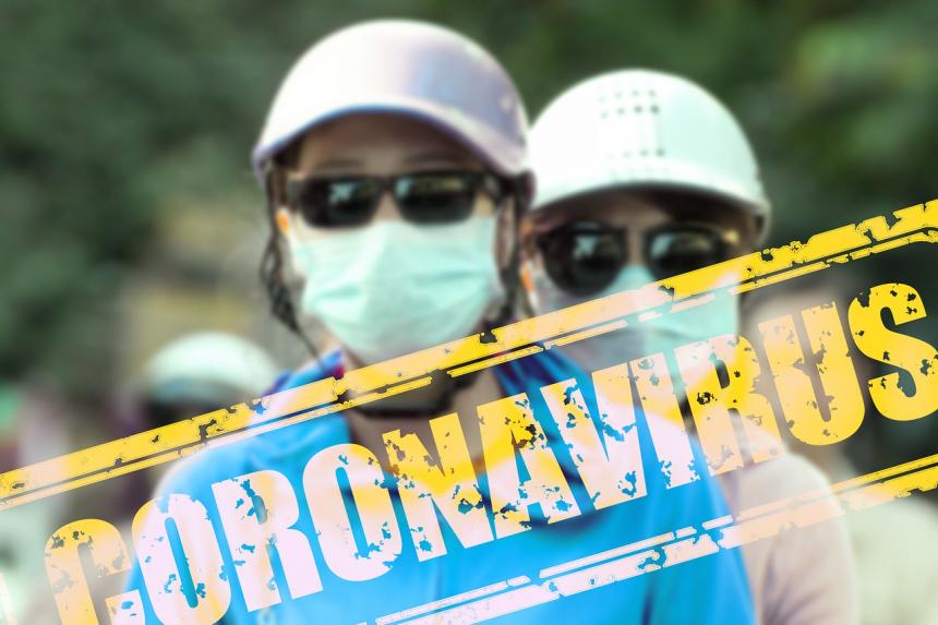 Two individuals shown with hard hats and masks with the text "Coronavirus" juxtaposed over the image of the people