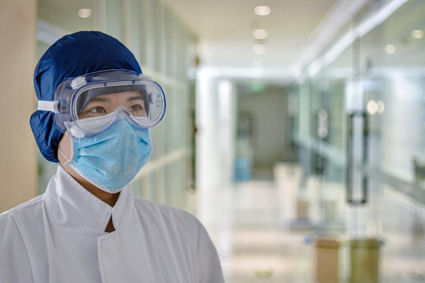 Medical worker wearing face mask and eye shield