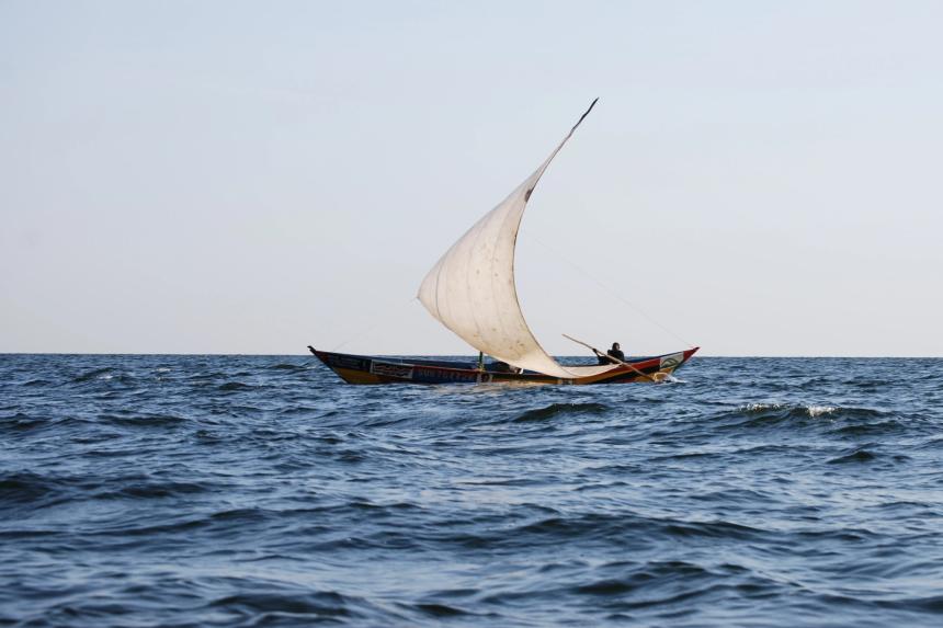 A sail-driven fishing boat shown in open water