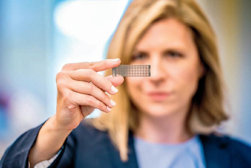 Dr. Laura Goodman holding one of the nanoscale PCR pathogen arrays her lab has developed.