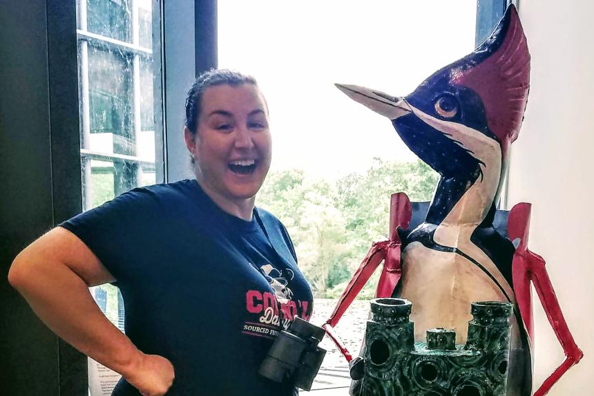 Danielle Sosnicki shown standing next to a bird sculpture.