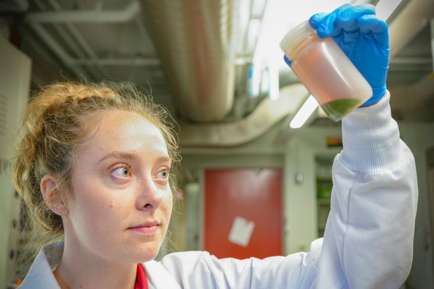 Amanda Bielecki in the lab holding up a sample