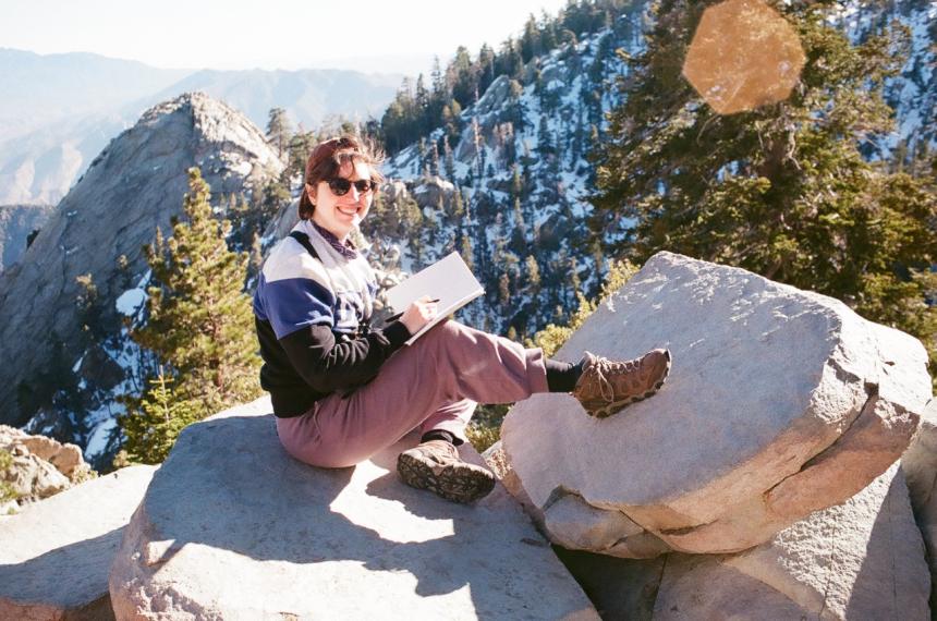 Maggie Swift sitting on a rock in the field