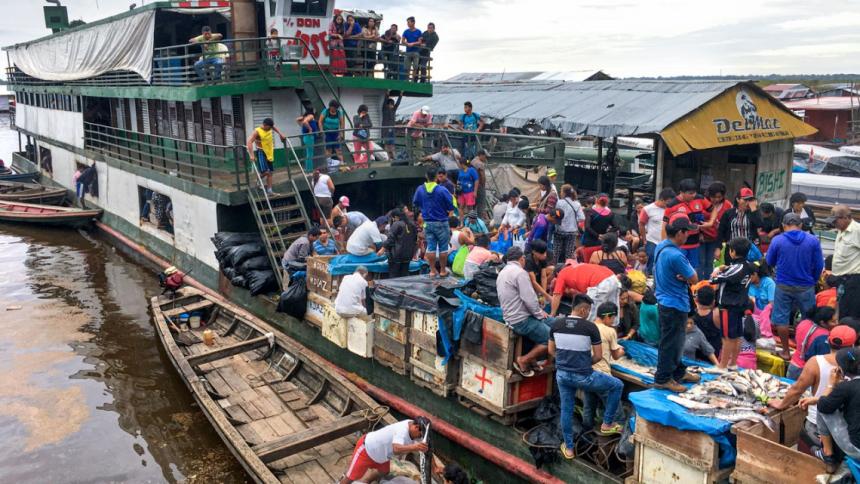 A ferry carrying passengers and cargo docks in the port city of Iquitos, along the Amazon River, where buyers climb on board to purchase fresh fish from wholesalers by Sebastian Heilpern.