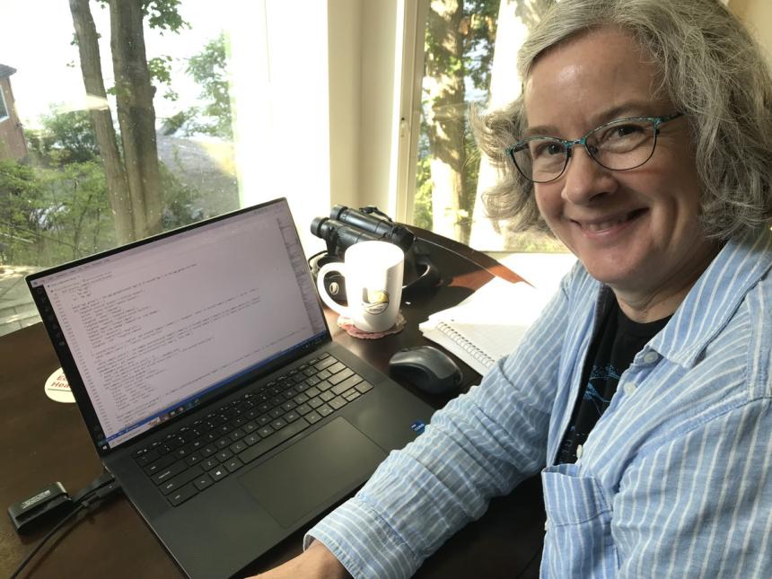 A portrait of Rachel Abbott sitting at her desk.