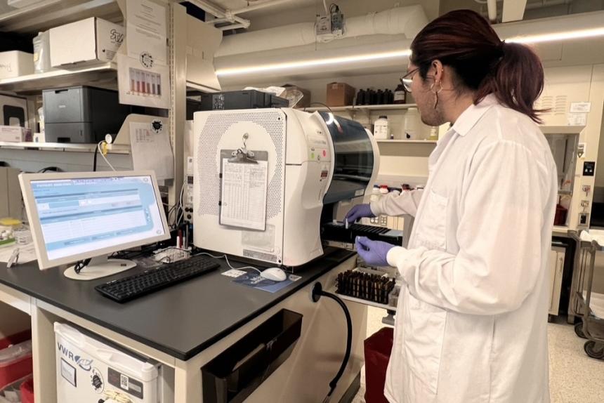 Student wearing a lab coat working in the lab