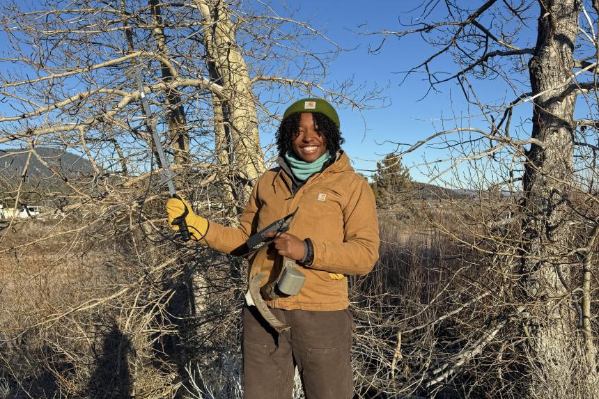 Victoria standing near trees with tracking equipment in hand.